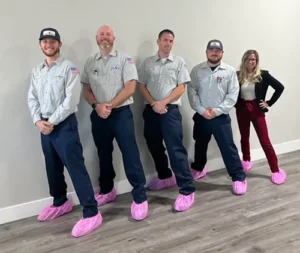 Five Allied Electrical team mambers in their pink booties lined up