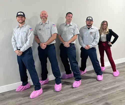 Five Allied Electrical team mambers in their pink booties lined up